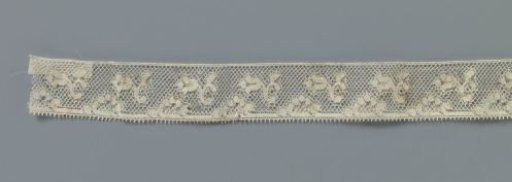 Strip of machine-made lace with cup-shaped flower on C-shaped branch