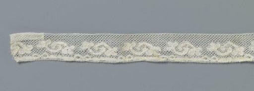 Strip of machine-made lace with interlocking C-shaped flower stems