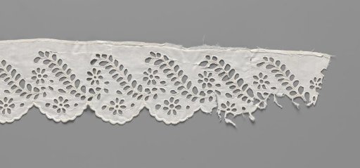 Strip of cotton with lace embroidery of daisies between feathered S-shaped leaves