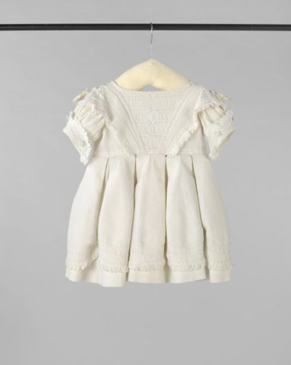 Child's dress with short puff sleeve with wide turned-down edge of white piqué, decorated with white passementerie and fringes