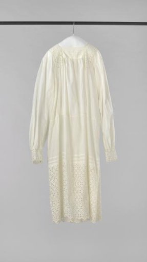Girl's dress with long sleeves, low waist and back fastening of white cotton, decorated with shirring, openwork and at the bottom with a very wide strip of English embroidery