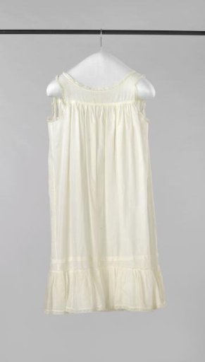 Sleeveless child's dress with high gathered waist, of white cotton with woven vertical narrow stripes, with lace along the neckline and armholes; at the bottom wide ruche and lace