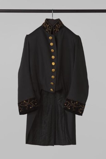 Coat of black wool, with gold-embroidered velvet collar and cuffs and with gilded buttons, decorated with fine scroll pattern