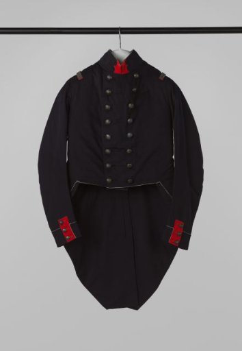 Closed coat of white-trimmed dark blue wool, with red patch on collar and cuffs, bright buttons with wall crown and on the skirt sections of the front panels large pointed flaps with buttons, part of a civic guard uniform