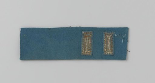 Cuff of blue cloth with two appliqués of silver embroidery