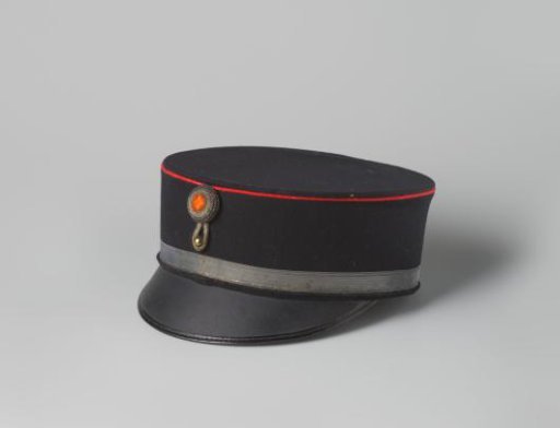 Kepi of black cloth, decorated with a red braid, narrow silver galloon and a round cockade with a silver-threaded fleur-de-lis, part of a civic guard uniform