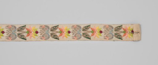 Belt ribbon of beige-colored silk decorated with a repeating motif in brocade work consisting of a flower with two leaves and two pomegranates
