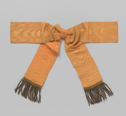 Shoulder knot of orange moiré ribbon with fringe of gold thread with a pin on the reverse side