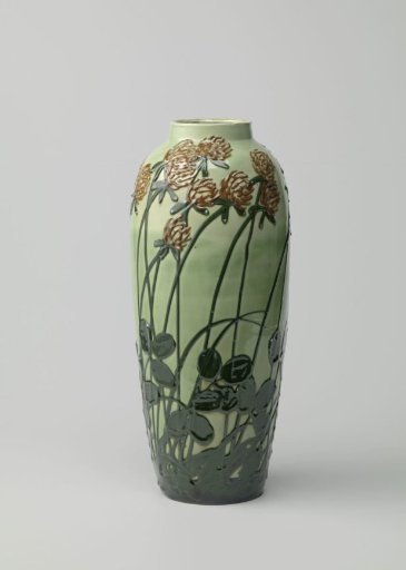 Earthenware vase, decorated in relief with clover in dark green and red on a light green ground