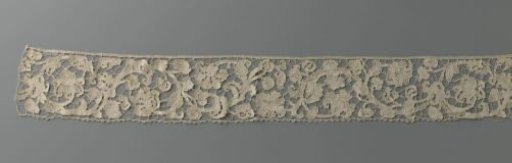Strip of needle lace with exotic flowers on a wavy vine