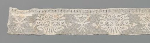 Strip of bobbin lace with a striped flowerpot and V-shaped bouquet