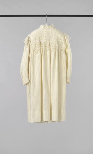 Girls' dress with long sleeves, of patterned net fabric (?) with stripes and block motifs; decorated with yoke and strip of border fabric with machine-made English embroidery
