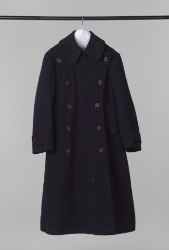 Coachman's jacket of navy blue wool, with flat round collar, ten black leg buttons, two slash pockets, long sleeve with band and button closure, and back split