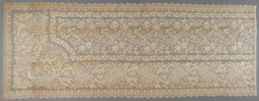 Machine-made lace with upright floral and foliate scrolls within scalloped borders