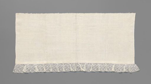 Linen cloth with at the bottom a strip of bobbin lace with a tangle of small flowers and short vines with buds