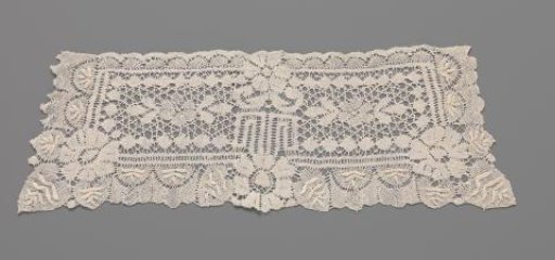 Cuff of bobbin lace with a symmetrical pattern with three large and three smaller rosette flowers