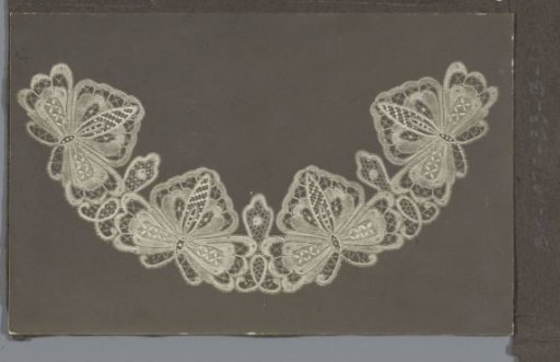 Photograph of a lace collar or fan leaf with four butterflies