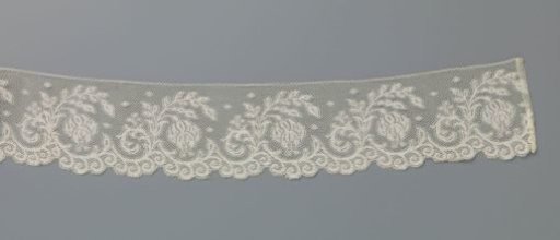 Strip of machine-made lace with fuchsia flower in C-shaped branch