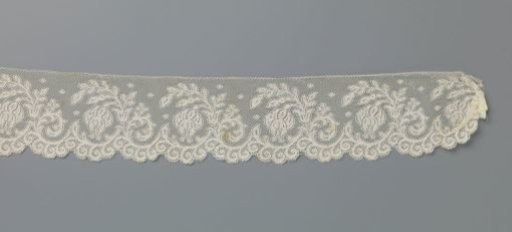 Strip of machine-made lace with fuchsia flower in C-shaped branch