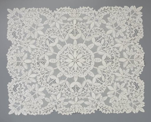 Dress of bobbin lace with a rosette surrounded radially by golden rain branches and flowers