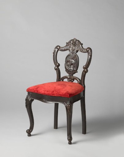 Chair with relief of a lion in the back. Loose seat upholstered in red velvet