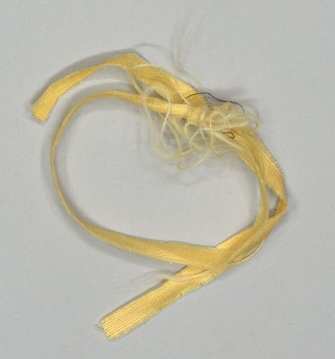 Fragment of a bed garniture of yellow watered wool with green trim and hanging tassels