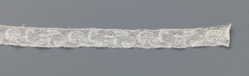 Strip of bobbin lace with a flower stem alternating with a drop-shaped leaf