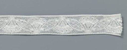 Insert of machine-made lace with a goblet flower between two pointed oval leaves