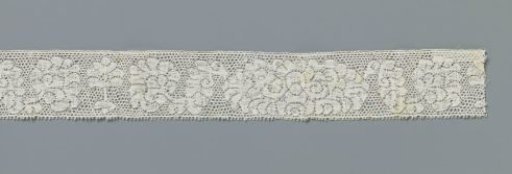 Strip of bobbin lace with 'little tree' between oval peony motif