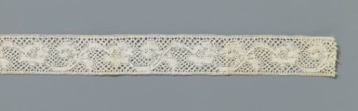 Strip of appliqué lace with a row of lying S-shaped flower stems