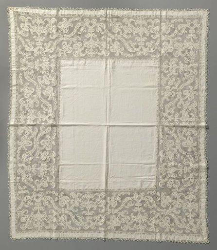 Tablecloth of linen with a wide border of filet lace with arabesque leaves and lilies