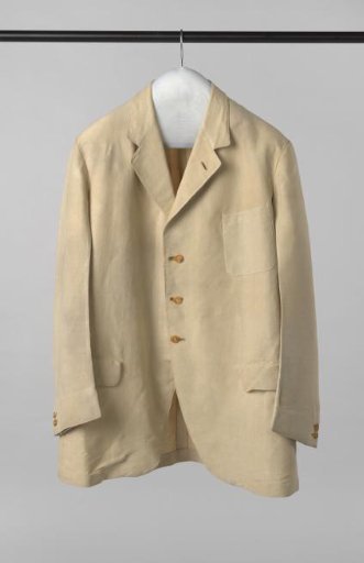 Lightly tailored jacket of beige cotton, with buttoned legs, small narrow lapels, two hip pockets with flap, horizontally sewn back band and sewn-on pocket top left