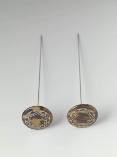 Hatpin of imitation tortoiseshell, inlaid with white metal