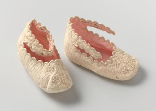 Child's slipper of cream-colored waffle piqué, embroidered with beige silk flowers and trimmed with scalloped shells