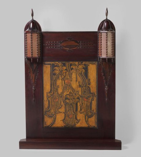 Fireplace surround consisting of a framework with two light ornaments around a wooden batiked panel