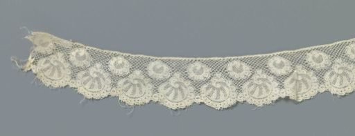 Strip of machine-made lace with round shell forms