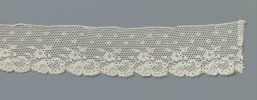 Strip of machine-made lace with C-shaped leaf and fan-shaped flower
