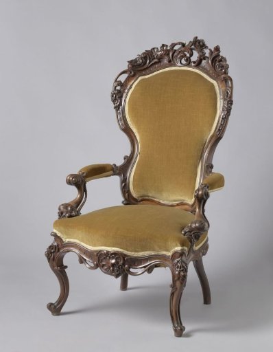 Armchair of Mahogany with a Violin-Back. Decorated with Rocaille Work and Partially Openwork Floral and Leaf Motifs. Back and Armrests Upholstered.