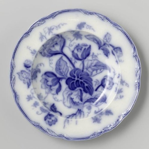 Plate with a flowering plant on the surface and rim