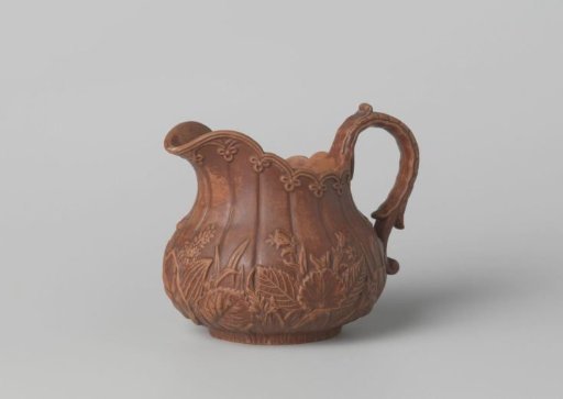 Milk jug, shaped, with flowers and leaves in relief