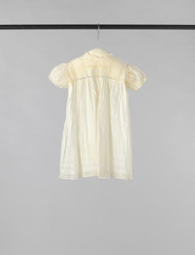 Children's dress with short sleeve of white linen, decorated with lace edges, gathering and white embroidered and openwork loose flowers.