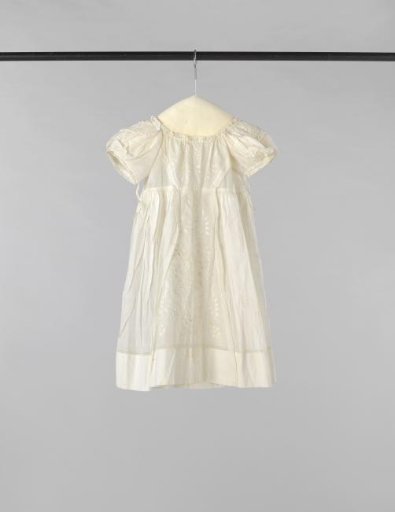Children's dress with high waist and back fastening with ribbon ties of white batiste, front decorated with a wide plumetis insert and also with plumetis on the short puff sleeve.