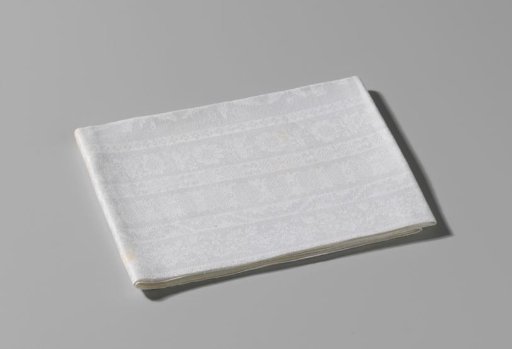 Damask napkin with ornamented longitudinal stripes within a border with volutes, flowers and a flower basket