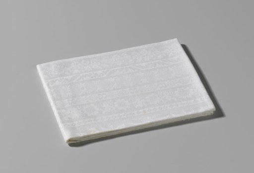 Damask napkin with ornamented lengthwise stripes within a border of volutes, flowers and a flower basket