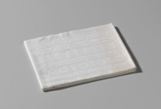 Damask napkin with ornamented lengthwise stripes within a border of volutes, flowers and a flower basket