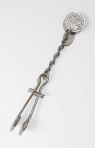Skirt supporter of nickel-plated copper with an unadorned waist hook and round clasp, decorated with a floral motif