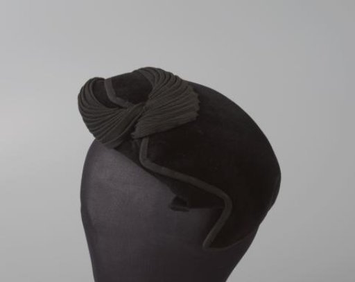 Cap of shaved black felt, decorated with a curled drapery of black grosgrain ribbon