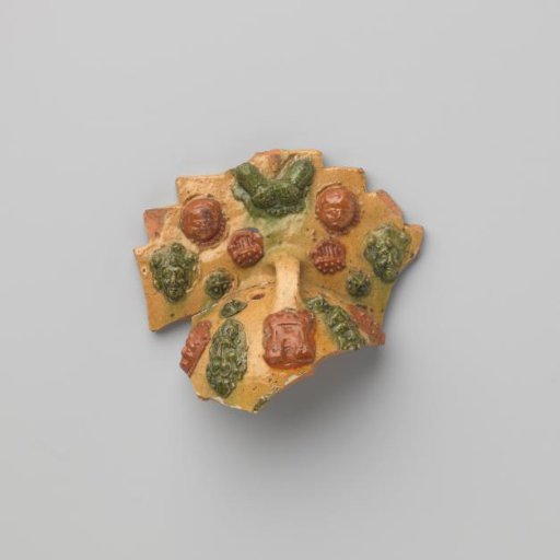 Fire clock, fragment of a toy, with handle, decorated in relief with double acorns and human heads