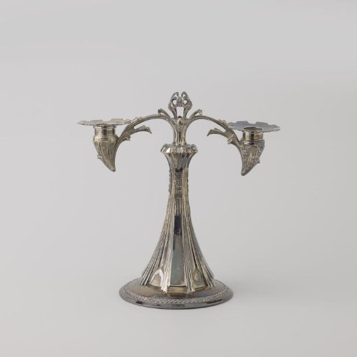 Candelabrum on a round foot. Two curved arms emerge from the stem