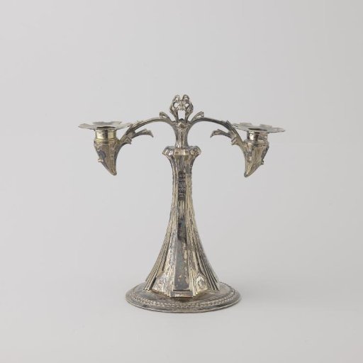 Candelabrum on a round foot. Two curved arms emerge from the stem